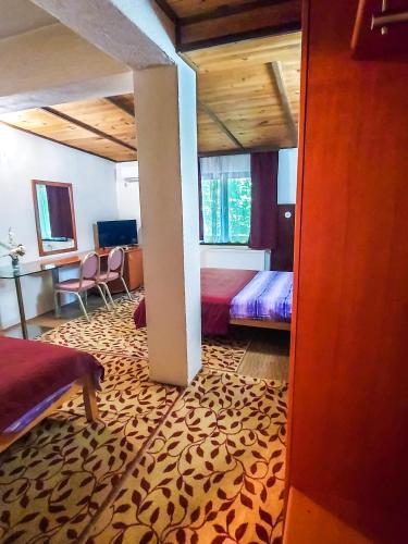 a bedroom with two beds and a room with a leopard rug at Hotel Rimski Most in Sarajevo