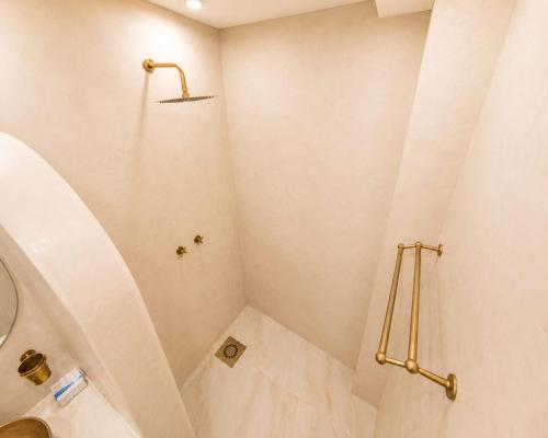 a white bathroom with a shower with a sink at Dar-Vida Guesthouse in Imsouane