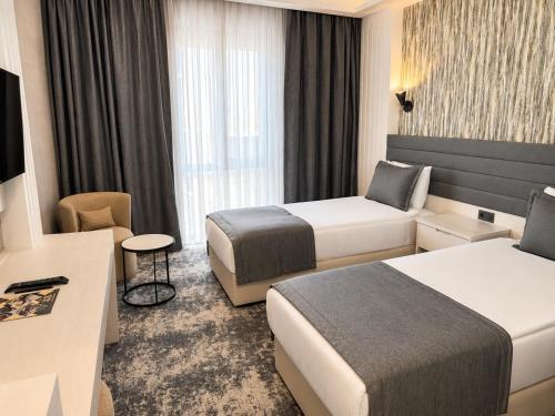 a hotel room with two beds and a television at Yeşilyurt Park Otel in Çorlu