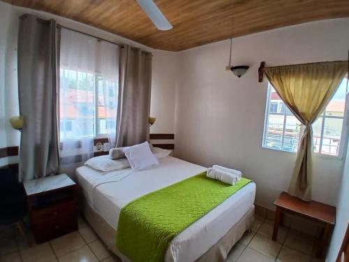 a small bedroom with a bed and a window at Hotel Casa Amelia in Flores