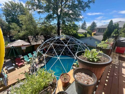 a patio with potted plants and a greenhouse on a deck at Quaint Attic Suite with Heated Pool Year-Round in Victoria