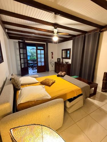 a bedroom with two beds and a couch at LES VILLAS PAMEYAQUE 2 F2 avec 1 piscine, 1 F3 avec 1 piscine privée, Superbe Vue Mer in Rivière-Salée