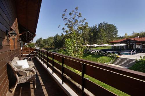 a balcony with two chairs and a view of a pool at Esterra Vini Guest House in Perushtitsa