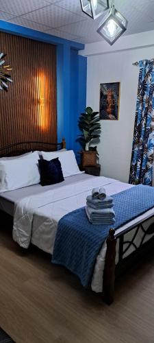 a bedroom with a large bed with a blue wall at Cozy Comfy Budget Friendly in San Fernando