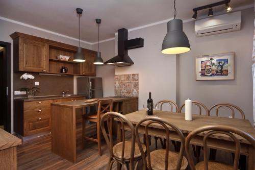a kitchen with a wooden table and chairs at Esterra Vini Guest House in Perushtitsa
