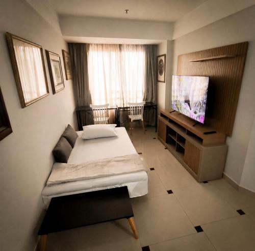 a room with two beds and a flat screen tv at VM Flats Guarulhos Aeroporto in Guarulhos