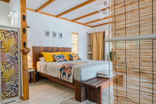 a bedroom with a bed with yellow pillows at Breeze Ocean Bungalow Moorea in Moorea