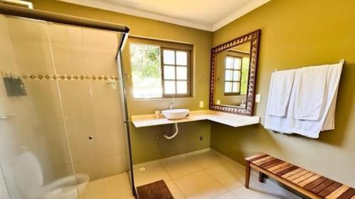 a bathroom with a shower and a sink and a mirror at Pousada Papyrus in Tiradentes