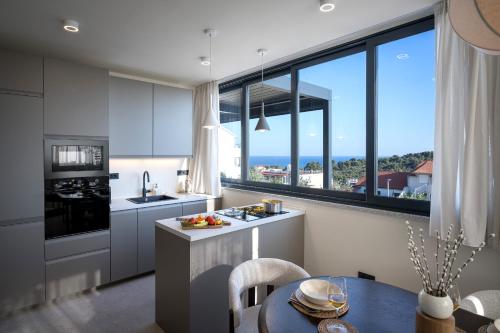 a kitchen with a table and a large window at Maslina Residence - Hvar in Hvar
