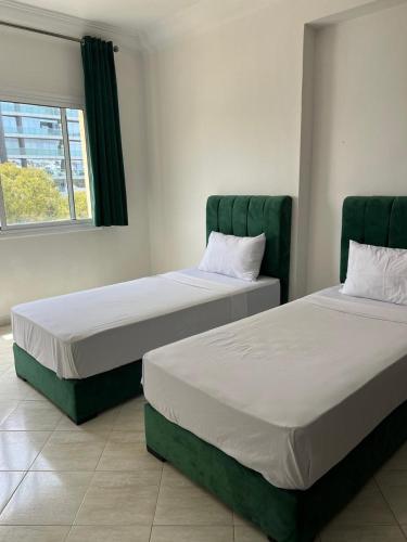 two beds sitting next to each other in a room at la corniche de tanger in Tangier