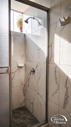 a shower with a glass door in a bathroom at Casona Blanca in Arequipa