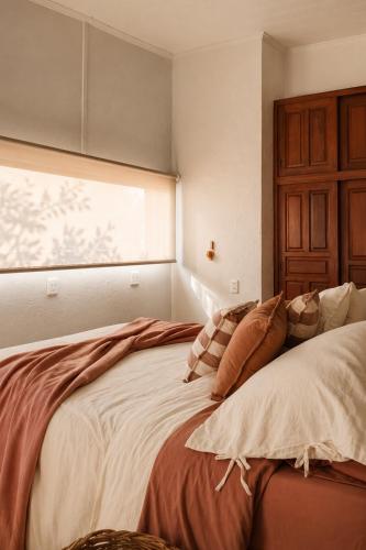 a bedroom with a bed with pillows and a window at Caelum House Apartamento Con cochera in Rafaela