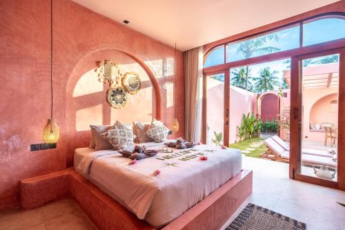 a bedroom with a large bed and a large window at Villa Solea in Gili Trawangan
