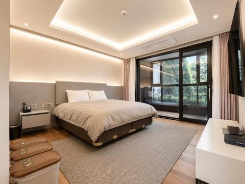 a bedroom with a bed and a large window at Seosansoo Golf & Resort in Seosan