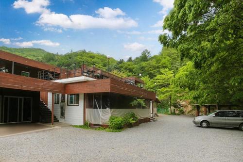 a house with a car parked in front of it at gapyeong semmul pension in Gapyeong