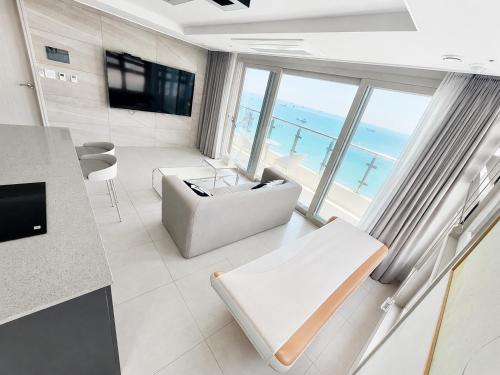 a living room with a view of the ocean at Elmomento Songdo in Busan