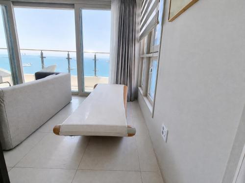 a living room with a bench in front of a window at Elmomento Songdo in Busan