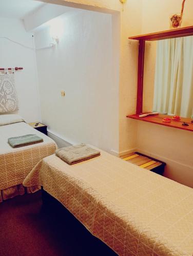 a small room with two beds and a window at Doña Minina in Posadas