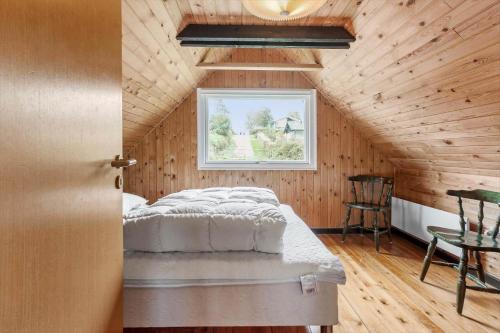 a bedroom with a bed in a wooden cabin at FY196-Brenderup-Fyn-Bakkevej-15 in Vedelshave