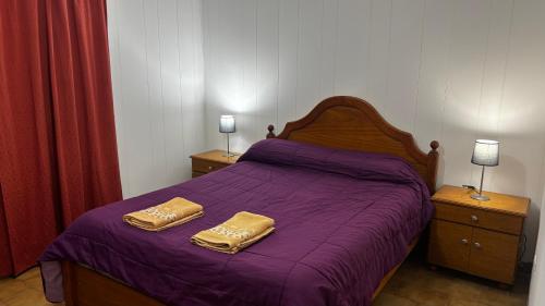 a bedroom with a purple bed with two towels on it at Soles del Boulevard in Córdoba