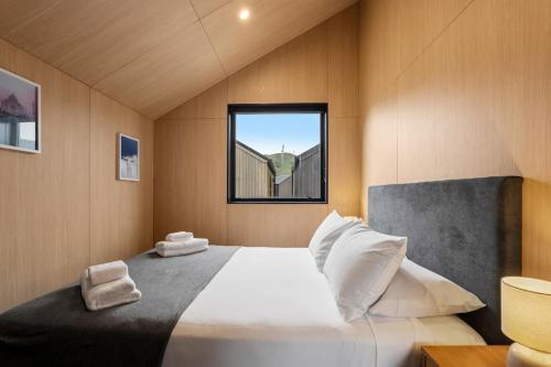a bedroom with a large bed with a window at Ski Villa with Carpark 40, Stylish Alpine Base in Queenstown