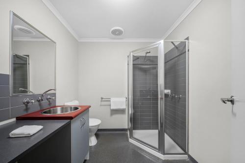 a bathroom with a shower and a sink and a toilet at Sovereign Views Apartments in Ballarat