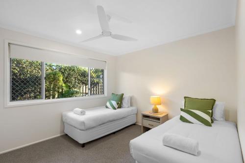 a living room with two beds and a window at Skippers Place in Noosaville