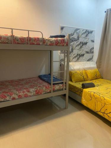 two bunk beds in a room with yellow sheets at Legacy Yumai in Kuala Rompin
