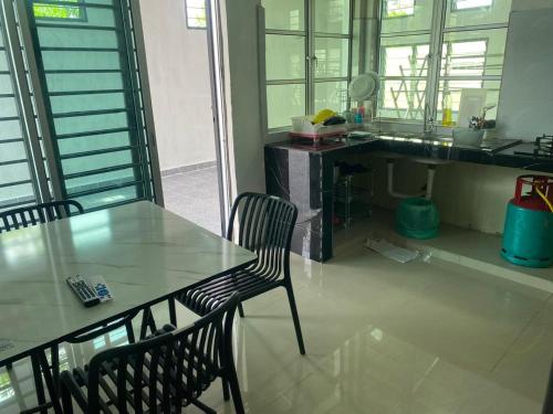 a dining table and a chair in a kitchen at Legacy Yumai in Kuala Rompin