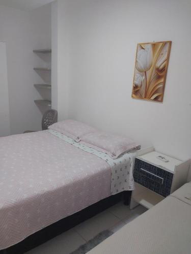 a bedroom with two beds and a desk and a mirror at Fênix hospedaria in Natal