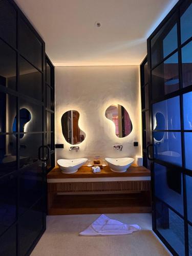 a bathroom with two sinks and two mirrors at Oh!Julia Hotel Komodo in Labuan Bajo