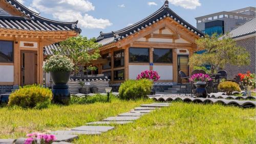 a house with a pathway leading to the front yard at Hanok Stay ieum in Gangneung