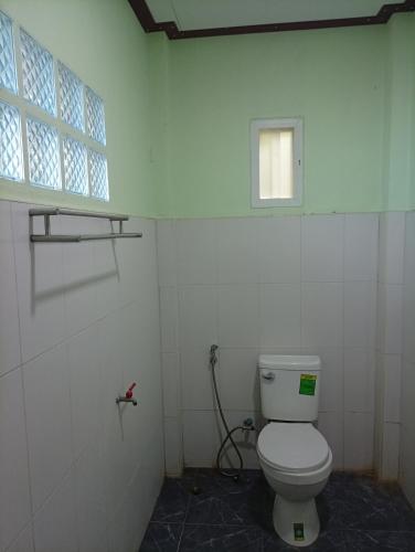 a bathroom with a toilet and a window at hadya home in Ko Yao Noi