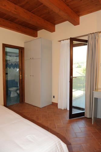 a bedroom with a bed and a sliding glass door at Country House Il Papavero in Bagnoli Irpino