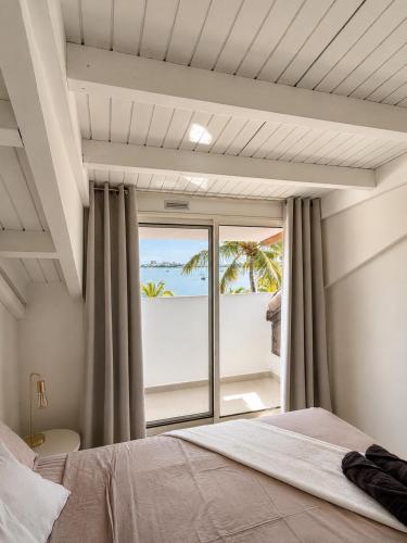 a bedroom with a bed and a view of the ocean at Sunset Paradise in Baie Nettle