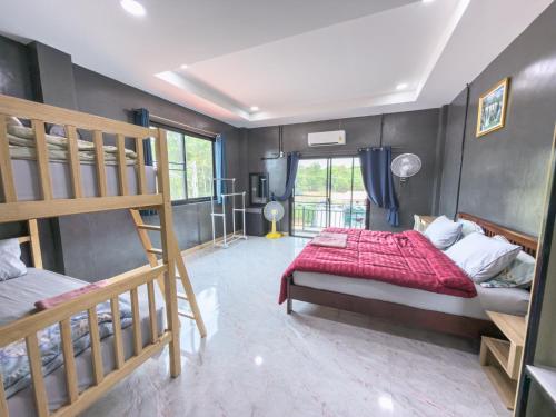 a bedroom with two bunk beds and a red comforter at NJ HOME Pool Villa in Ban Phe