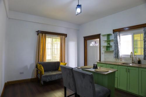 a kitchen with green cabinets and a table and chairs at Green Valley Luxe Apartments in Kingstown