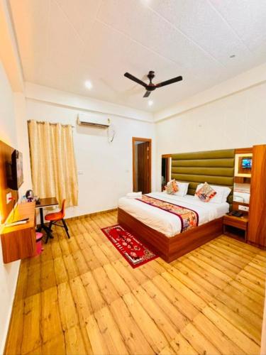 a bedroom with a bed and a desk and a television at Hotel Yuvan Palace - Agra in Tājganj
