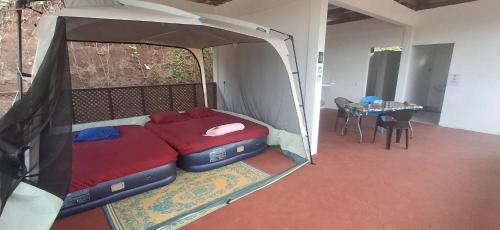 a bed in a tent in a room with a table at Camping Nany in Taputapuapea