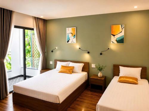 a bedroom with two beds and a window at Buddy January Villa in Hoi An