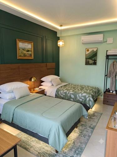 two beds in a room with green walls at Casa7Cielos in Monterrey