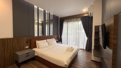 a small bedroom with a bed and a television at The RiverKwai Bridge Resort 2 in Ban Chuk Kum