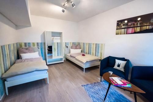 ein Wohnzimmer mit 2 Betten und einem Sofa in der Unterkunft Ferienwohnung Rath in Köln