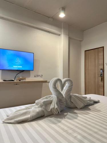 a towel heart sitting on a bed in a room at House Hotel Walking Street Pattaya in Pattaya