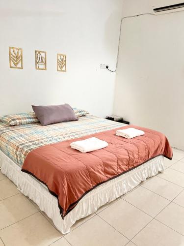 a bedroom with a bed with two towels on it at Solehah Homestay in Seri Iskandar