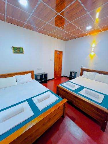 two beds in a room with two beds sidx sidx sidx at Chamikara Homestay in Sigiriya