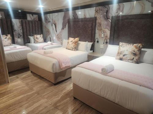 a hotel room with two beds and a couch at Europrime Hotels Lakefield in Benoni