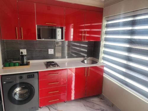 a kitchen with red cabinets and a washing machine at Europrime Hotels Lakefield in Benoni