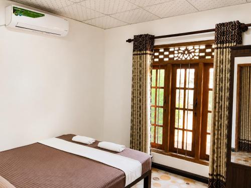 a bedroom with a bed and a window at MG Home Sigiriya in Inamaluwa