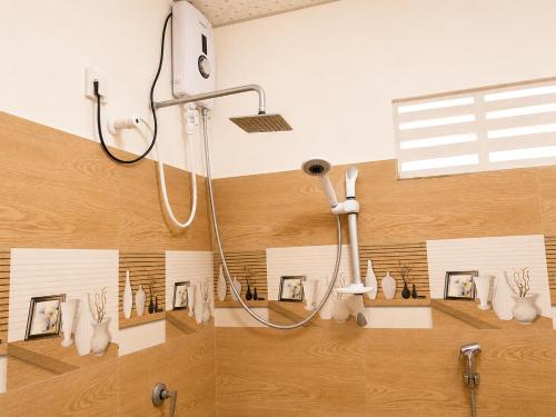 a bathroom with a shower with pictures on the wall at MG Home Sigiriya in Inamaluwa
